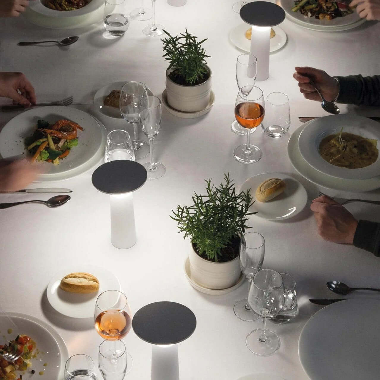 Elegant dining setup with the Rivo cordless table lamp providing ambient light on a beautifully arranged table.