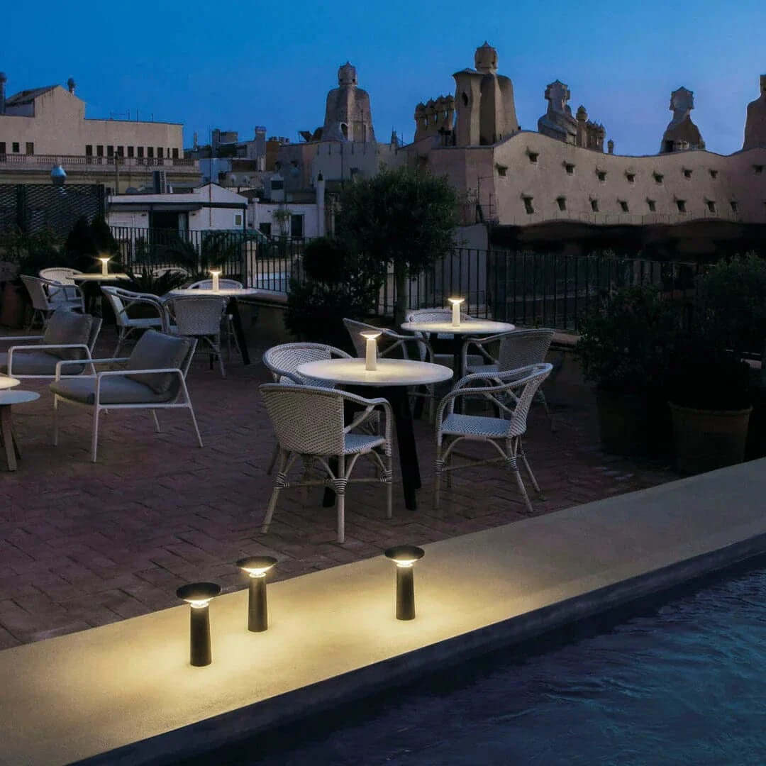 Rivo Cordless Table Lamp illuminating outdoor dining area at dusk, showcasing modern cordless table lamp design.