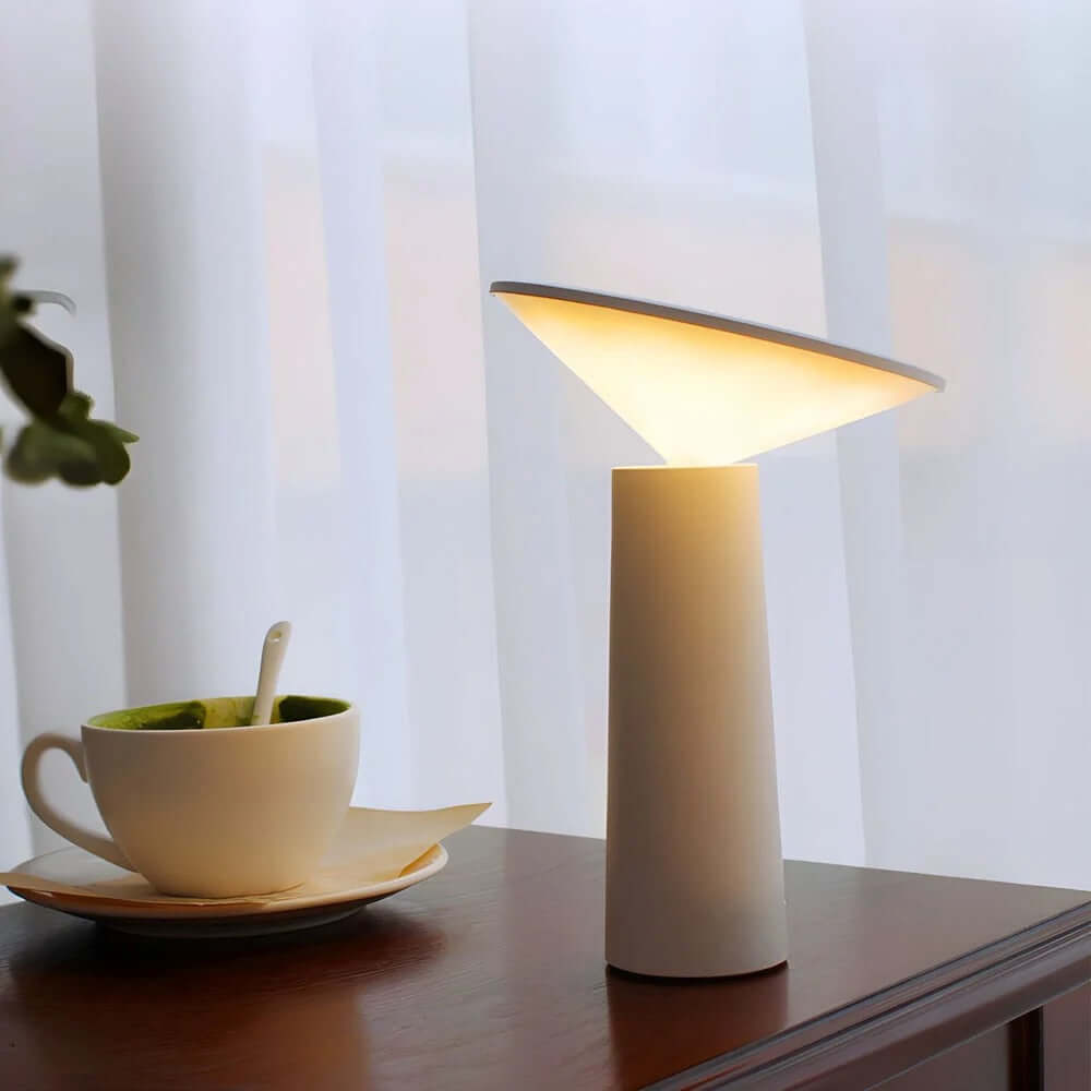 Rivo Cordless Table Lamp providing ambient light on a wooden table next to a cup of green tea.