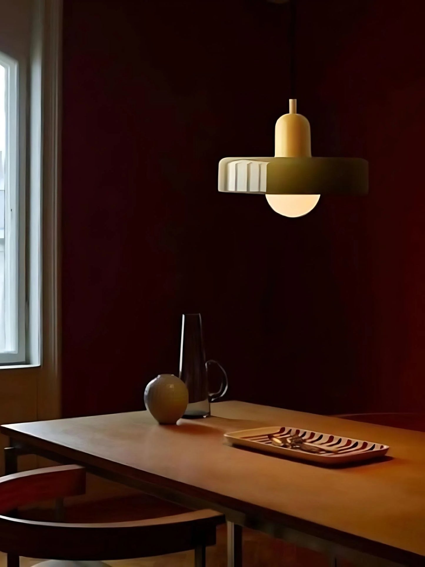 Dining room with a wooden table, chairs, and a pendant light fixture.