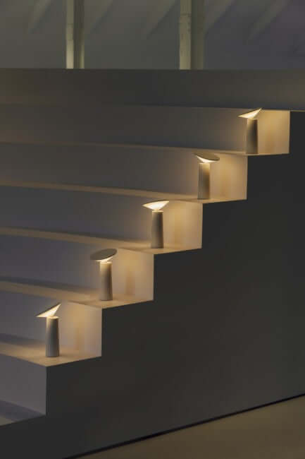 Rivo cordless table lamp illuminating steps with modern sculptural design for ambient lighting.