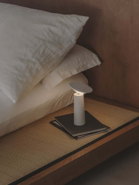 Rivo cordless table lamp on bedside table, providing stylish and adjustable ambient light with modern design.