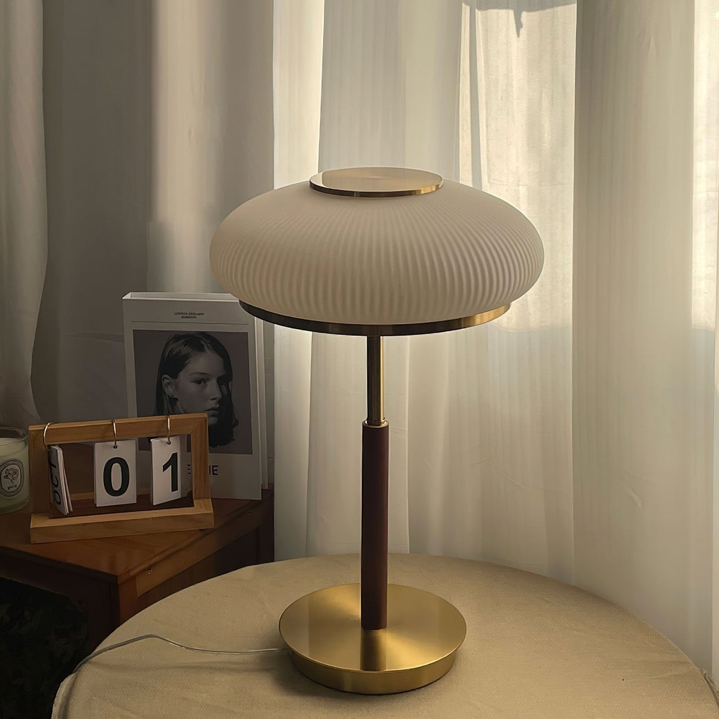 Matsutake Bloom Table Lamp – Elegant Table Lighting in a warm setting with a glass shade and gold accents.