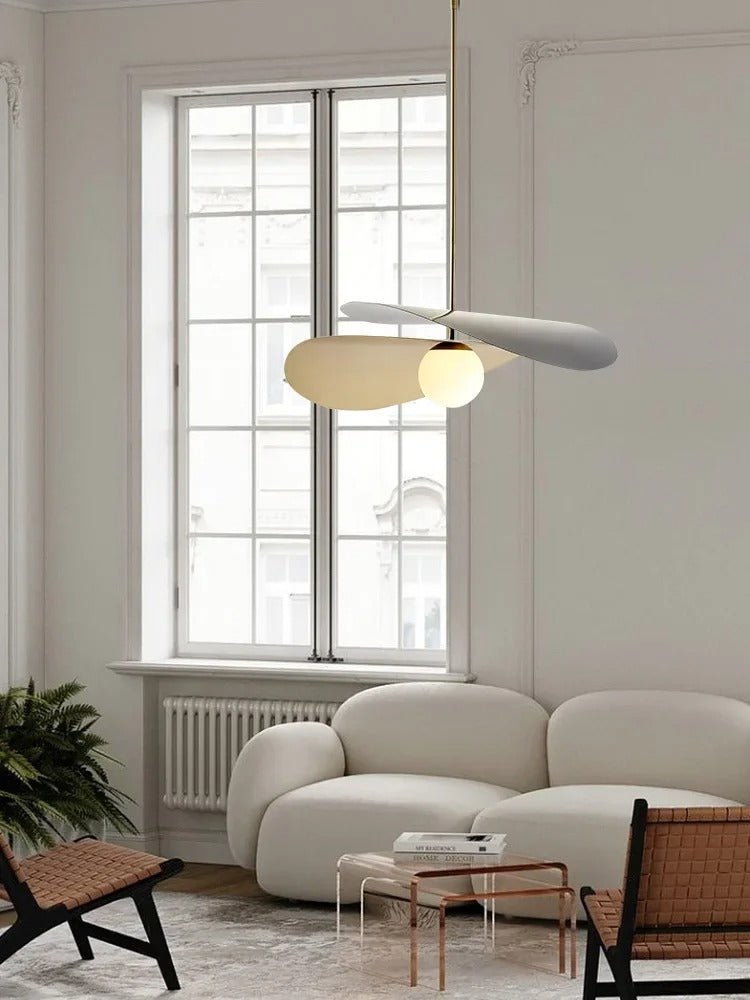 Olivia Pendant Light with frosted glass globe and modern brass finish over table