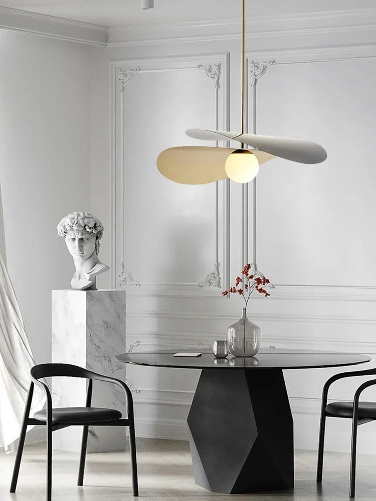 Olivia Pendant Light with frosted glass globe and modern brass finish over dining table