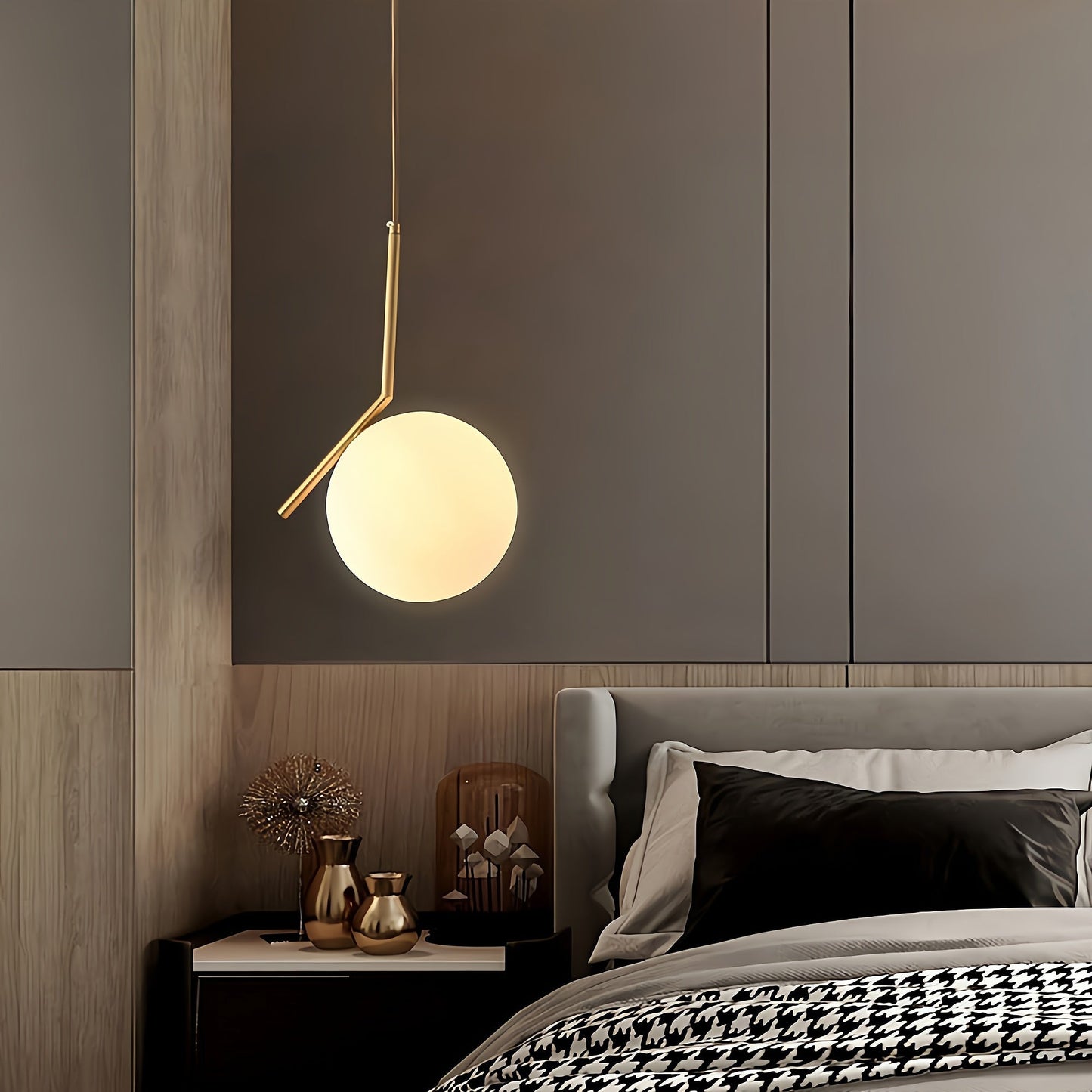 Modern bedroom with a hanging pendant light, bed, and decorative items.