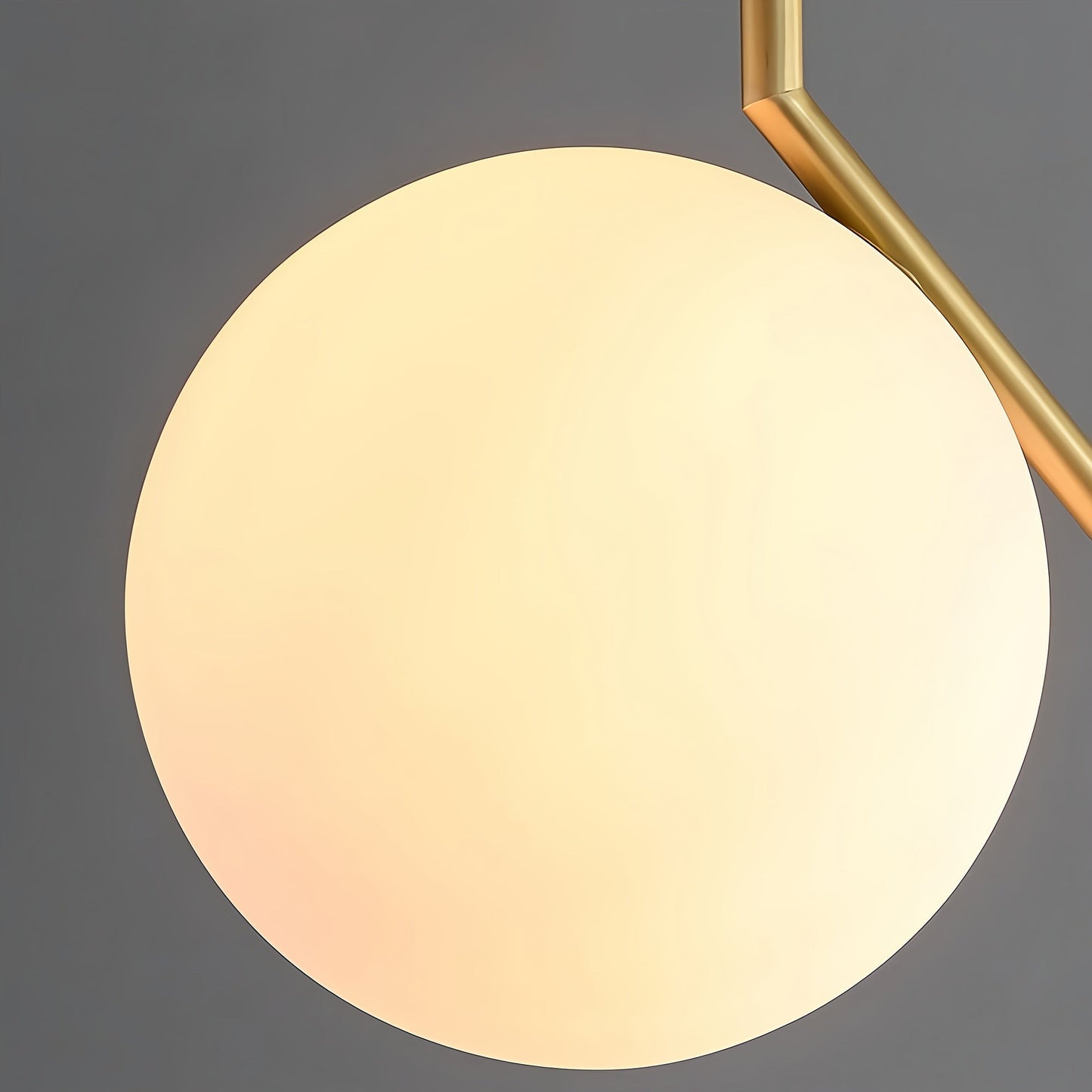 Round light fixture with gold frame on a dark background