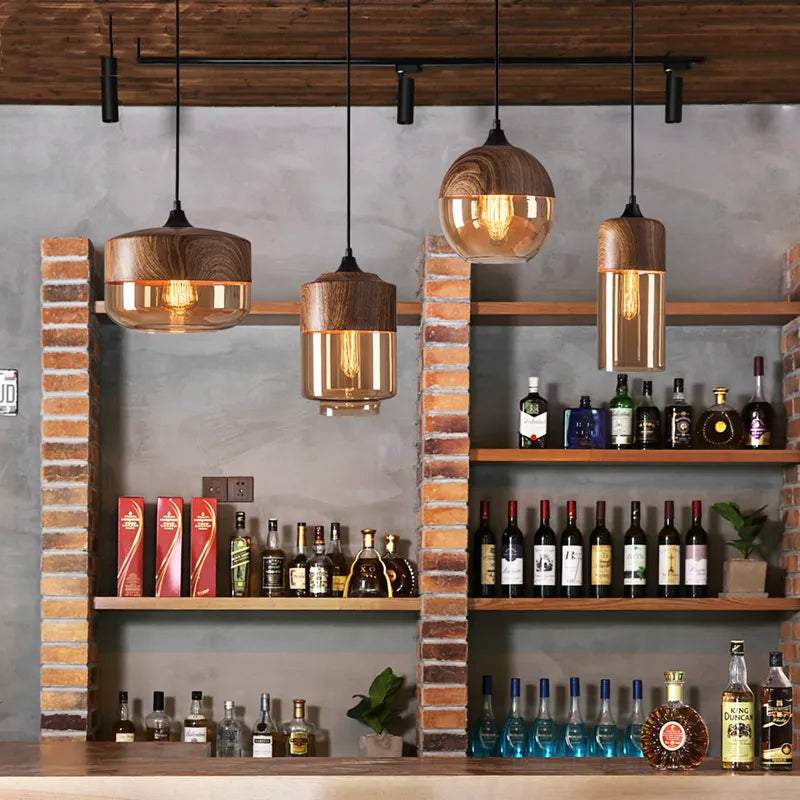 Alcohol bottles on shelves with wooden pendant lights in a bar setting