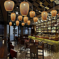 Interior of a restaurant with wooden pendant lights, tables, and chairs.