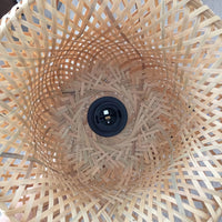 Close-up of a woven wooden lampshade with a black light bulb holder.