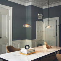 Modern interior with a marble table, chairs, and decorative items against a gray wall.