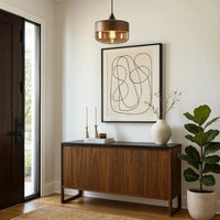 Wooden sideboard with decorative items in a room with a painting and plant.