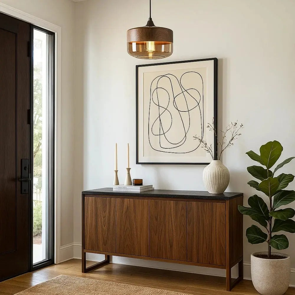 Wooden sideboard with decorative items in a room with a painting and plant.