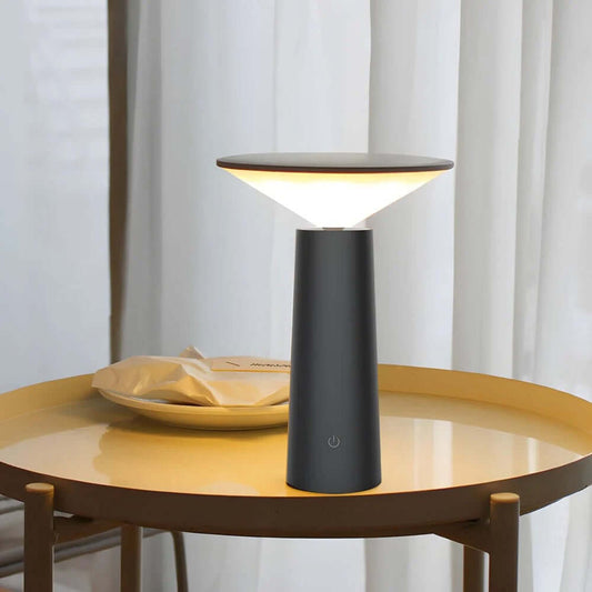 Rivo Cordless Table Lamp on a table, illuminating softly for a modern, sculptural ambience.