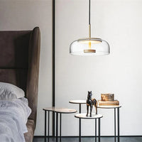Modern pendant light hanging above a bed in a bedroom setting.