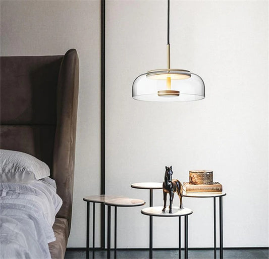 Modern pendant light hanging above a bed in a bedroom setting.