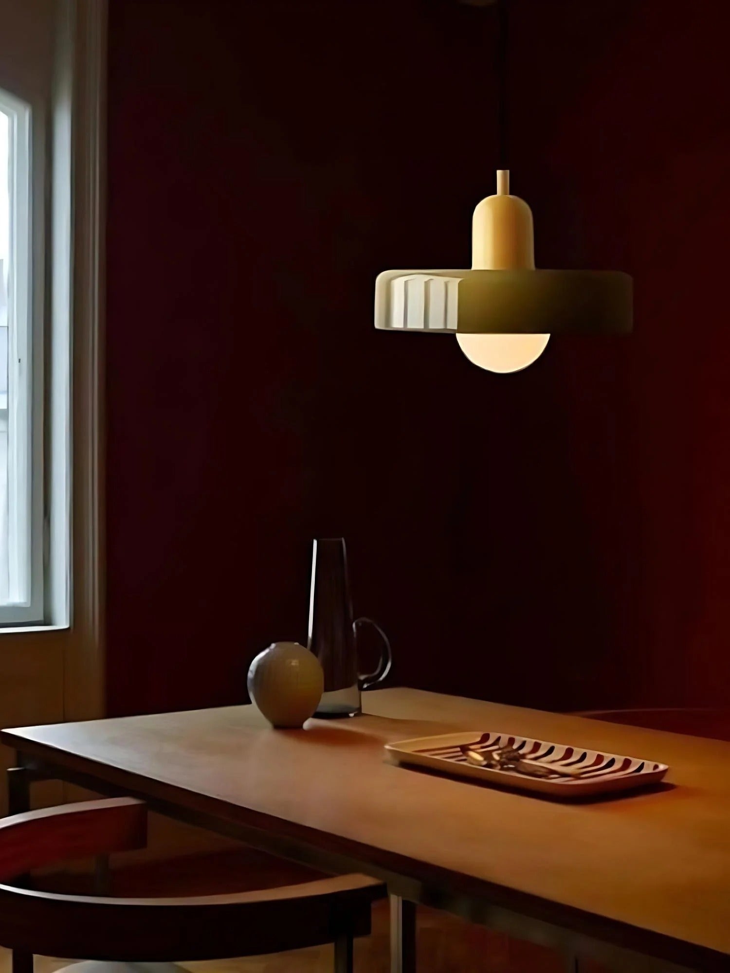 Dining room with a wooden table, chairs, and a pendant light fixture.