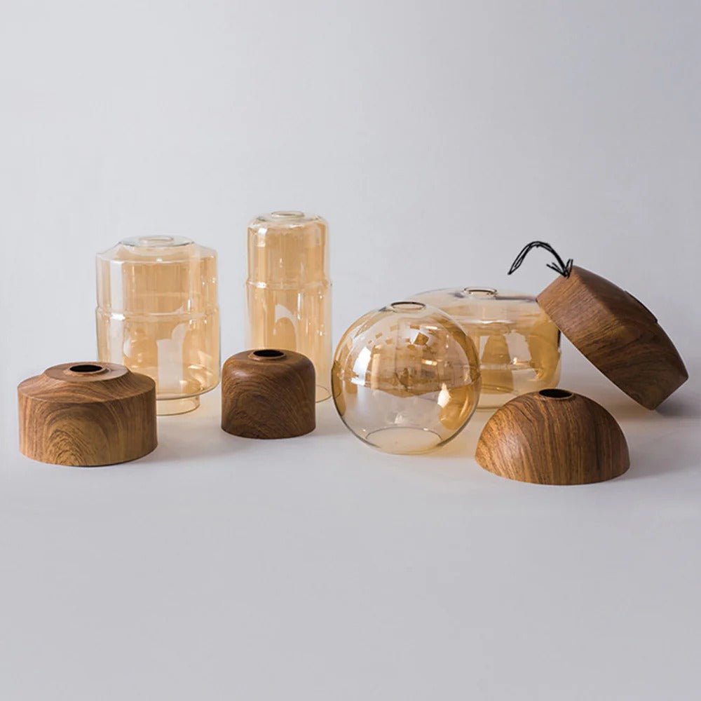 Collection of wooden and glass candle holders on a light gray background