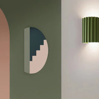Modern wall light fixture on a neutral wall with abstract wall art.