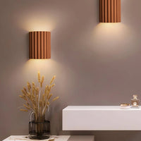 Modern wall lights on a neutral wall with decorative elements.