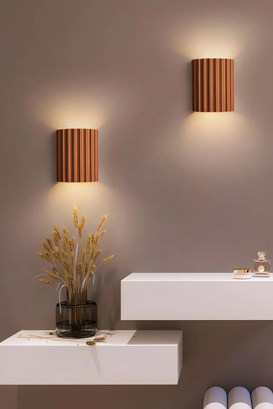 Modern wall lights on a neutral wall with decorative elements.
