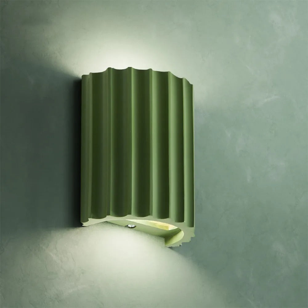 Green wall-mounted light fixture on a textured gray wall