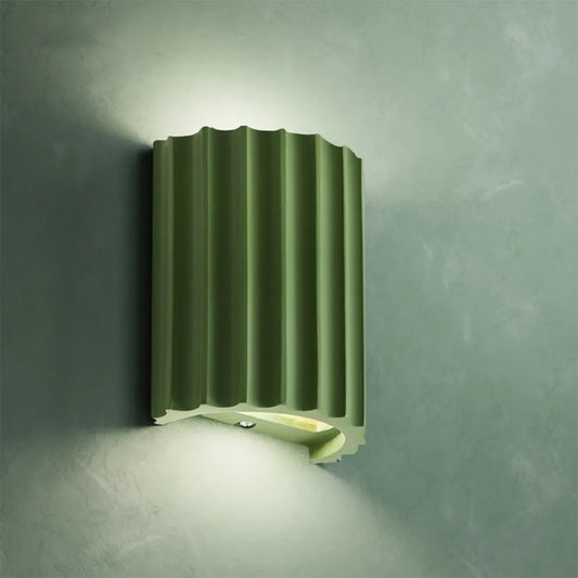 Green wall-mounted light fixture on a textured gray wall