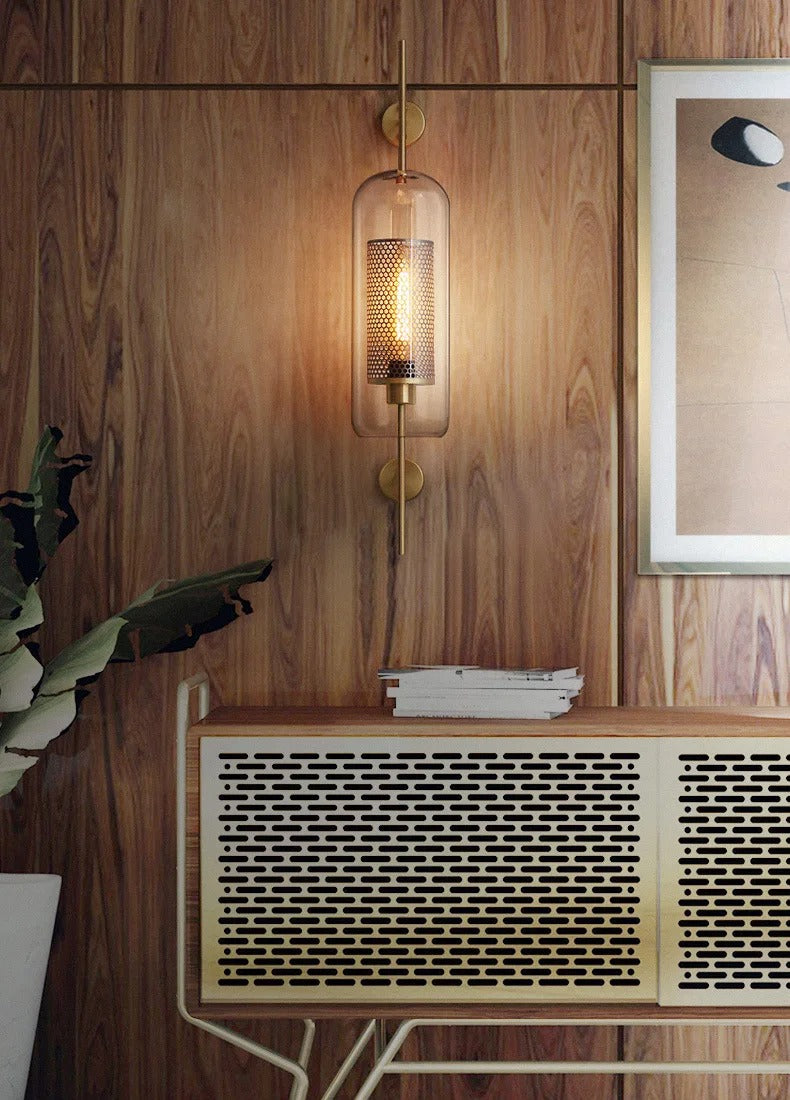 Decorative wall sconce with a wooden panel and framed picture in the background