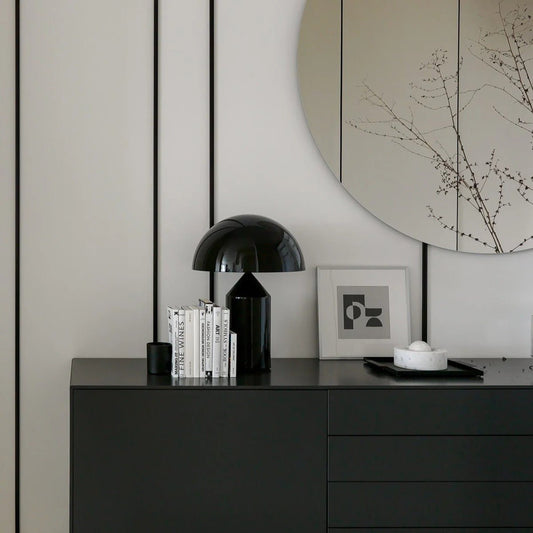 Modern interior with a black dresser, mirror, and decorative items.