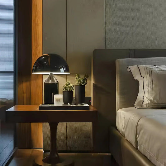Modern bedroom with a bed, nightstand, and decorative elements.