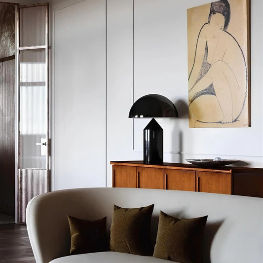 Modern living room with a black lamp, wooden cabinet, and abstract painting.