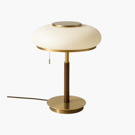 Table lamp with a white shade, gold base, and brown stem on a white background