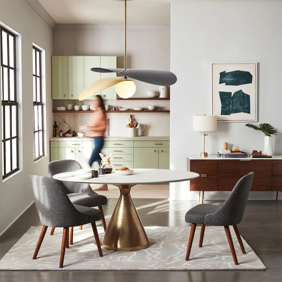 Olivia Pendant Light with frosted glass globe and modern brass finish over dining table