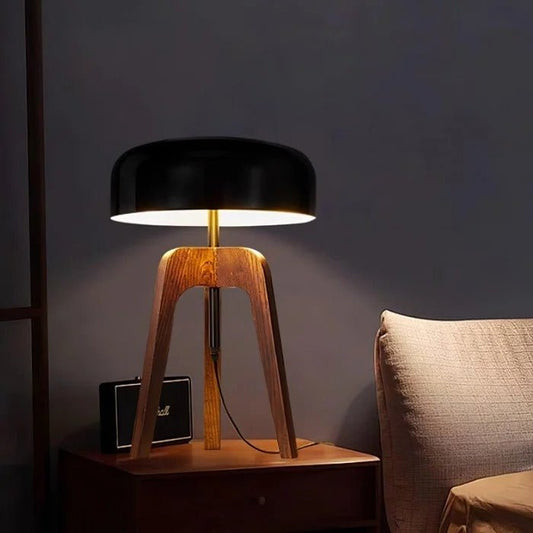 Table lamp with wooden base and black shade on a dark background