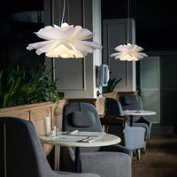 Modern interior with white flower-shaped pendant lights in a restaurant setting.