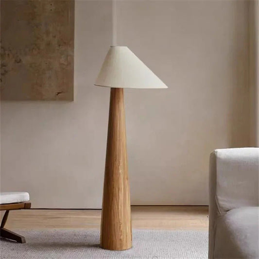 Floor lamp with wooden base and white shade in a room setting