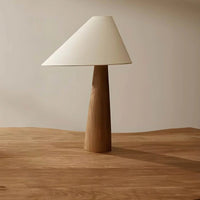Table lamp with wooden base and white shade on a wooden surface