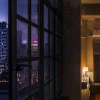 Cityscape view from a window with interior lighting in a modern room.