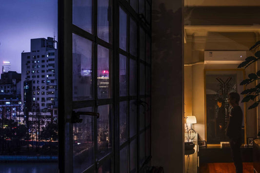 Cityscape view from a window with interior lighting in a modern room.
