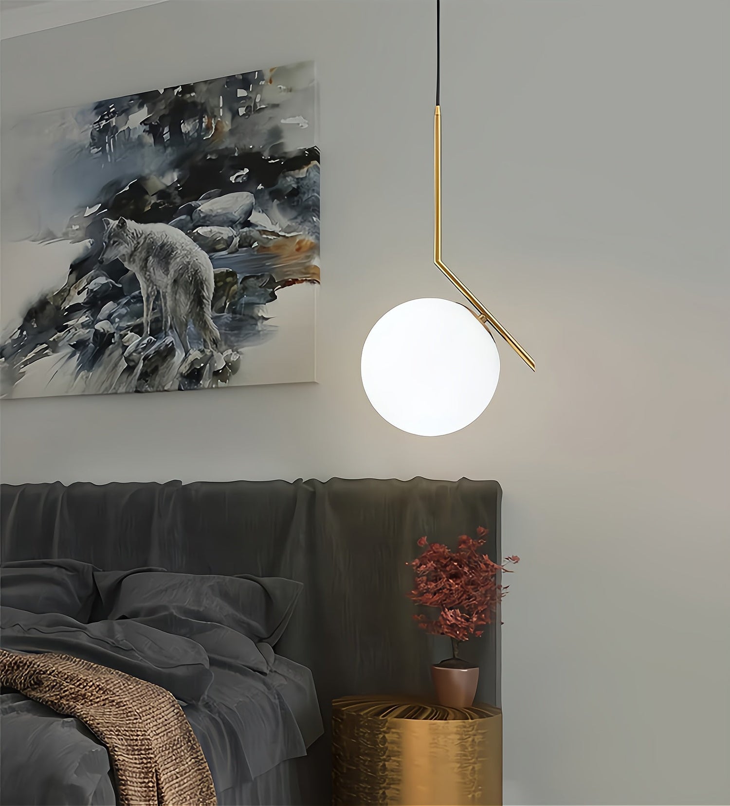 Modern pendant light hanging above a bed with a painting of a wolf on the wall.
