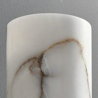 Marble-patterned cylindrical object against a gray background